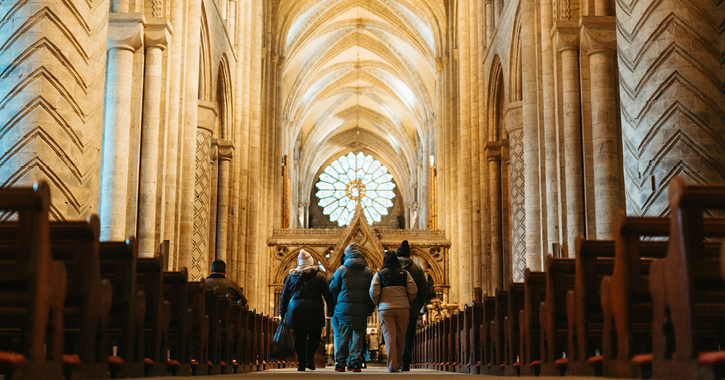 Group of people walking through Nave at Durham Cathedral 